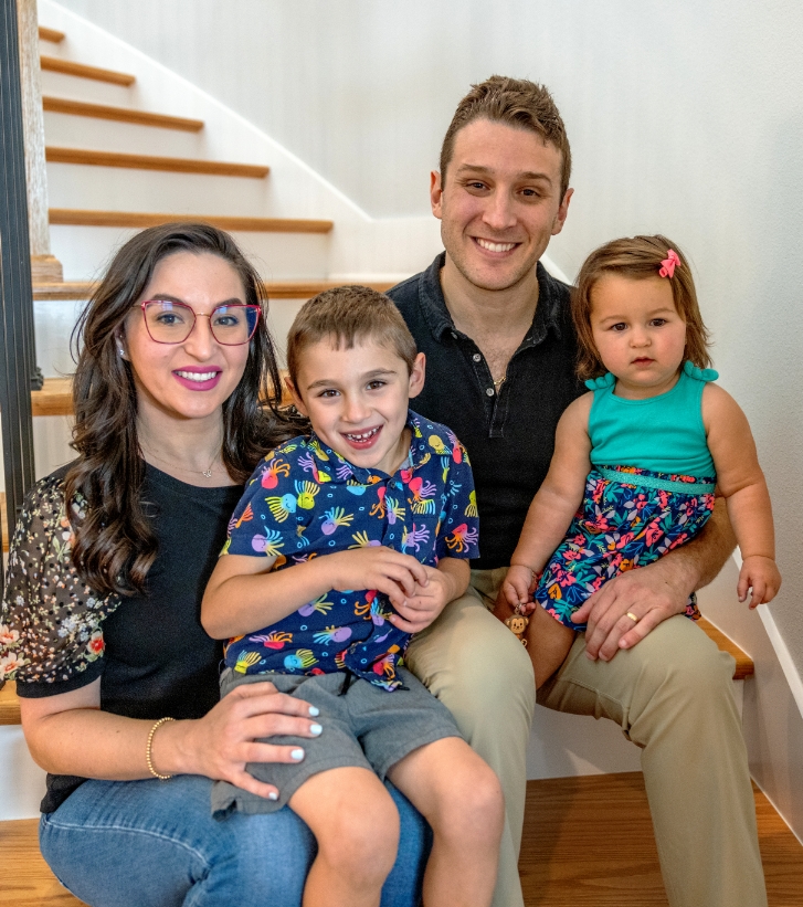 Doctor Weiss sitting at bottom of staircase with his wife and two children