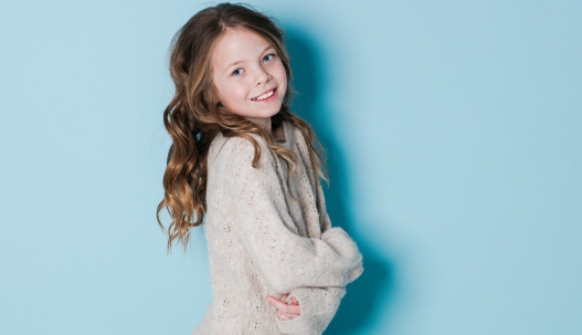 Smiling young girl in white sweater